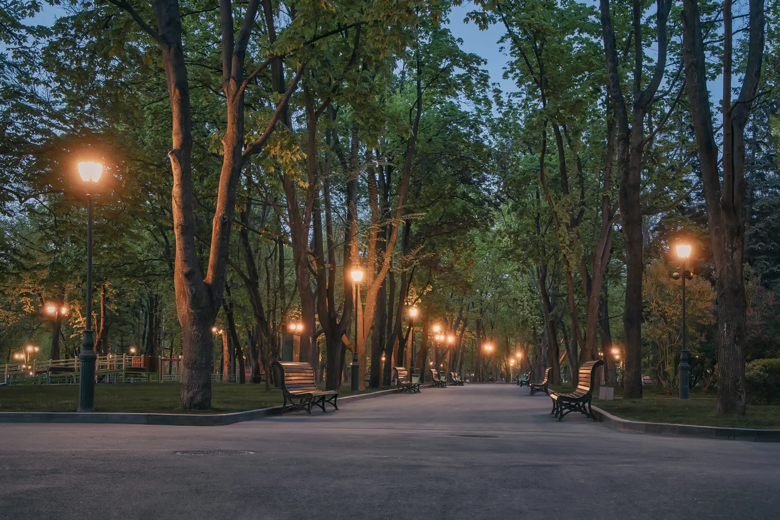Decorative post tops along a park path at dusk